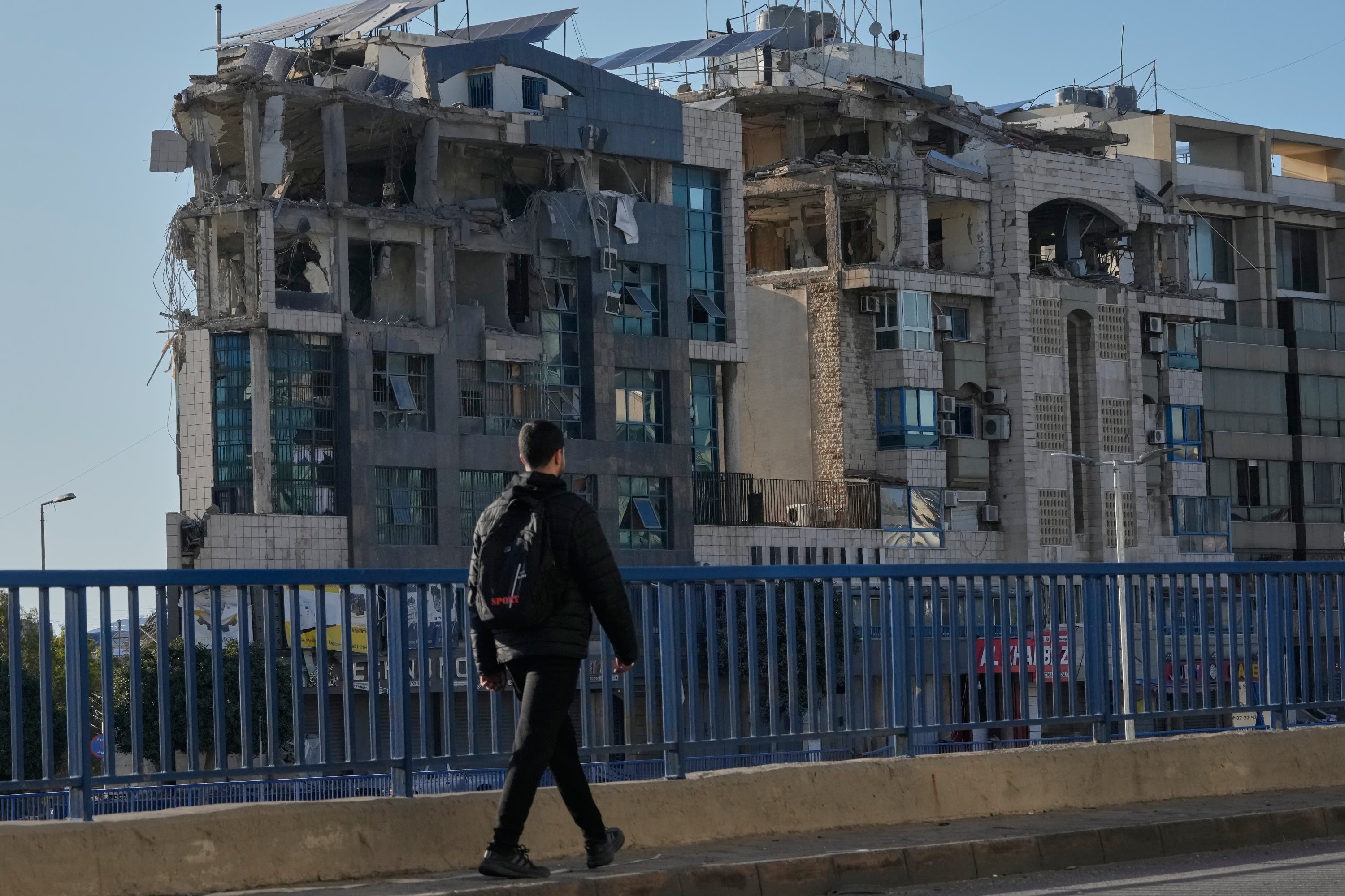 A man walks in front a building that was hit in an Israeli air strike near the airport road in Beirut, Lebanon