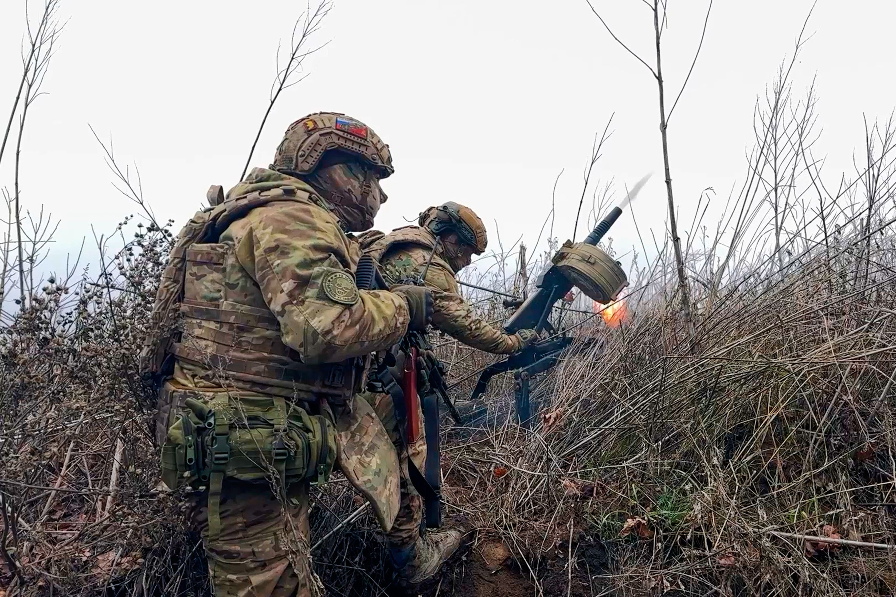 Russian soldiers fire a grenade launcher towards Ukrainian positions in an undisclosed location in Ukraine