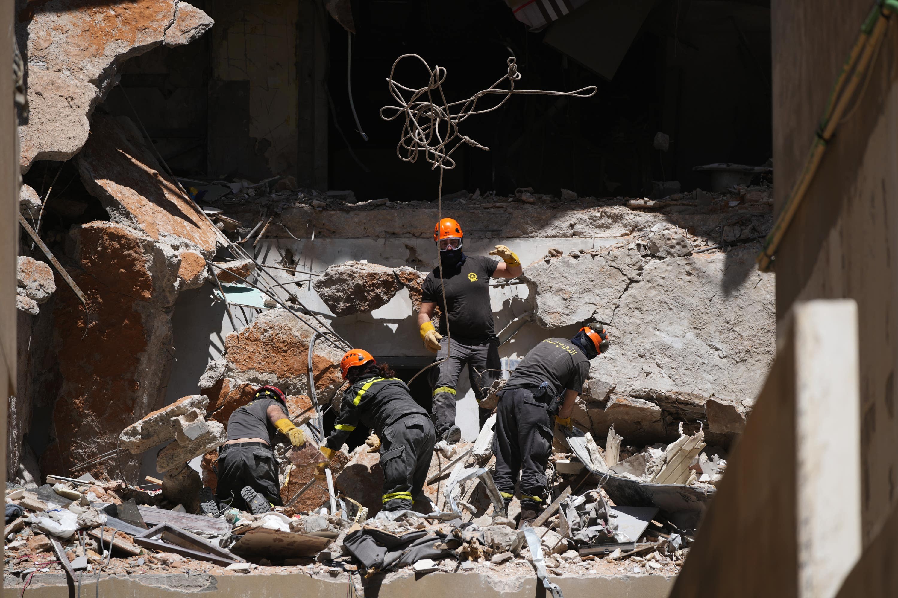 Lebanese civil defence workers search through rubble following an Israeli air strike in central Beirut