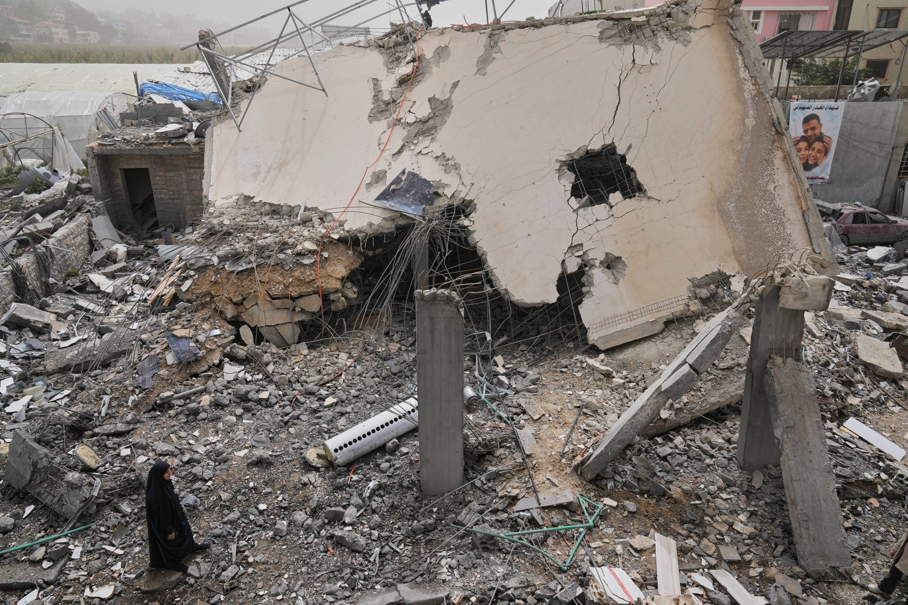 A woman checks a destroyed house that was hit in an Israeli airstrike in Saksakiyeh village, south Lebanon
