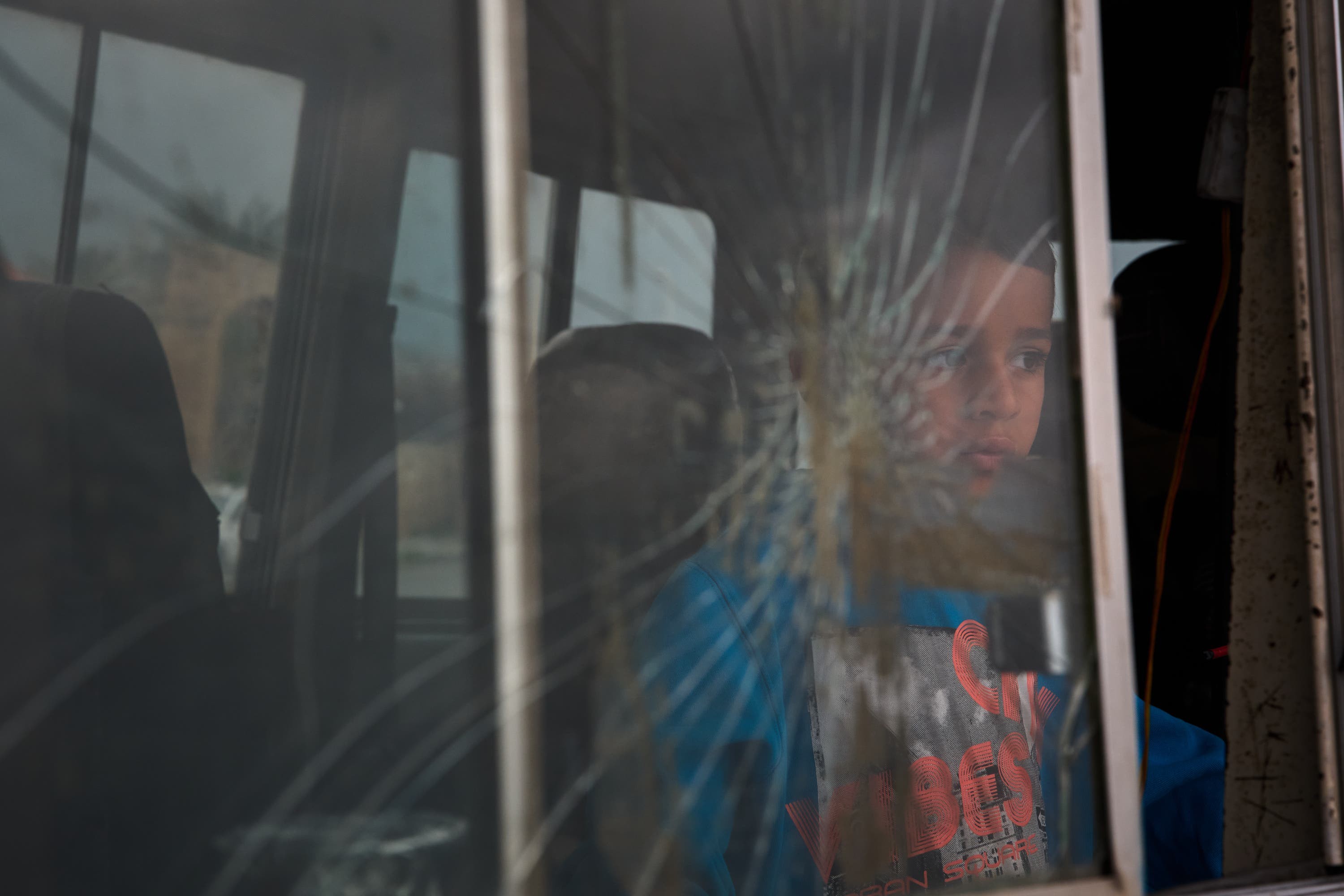 A boy who fled with his family following Israeli strikes in southern Lebanon sits inside the van they are using as shelter in Sidon, Lebanon,