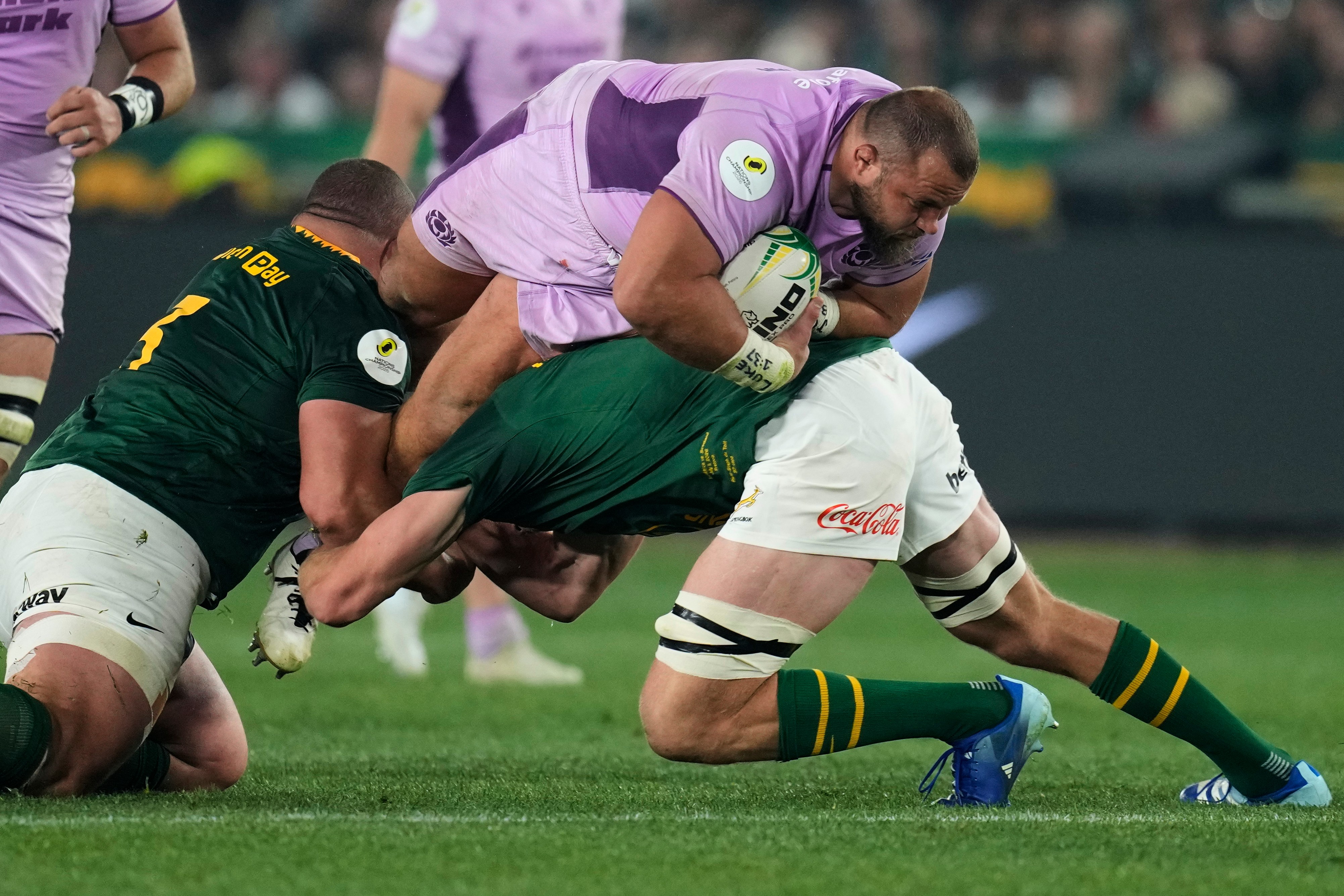 Scotland's Pierre Schoeman, top, is tackled by South Africa's captain Pieter-Steph du Toit, right, and his teammate Wilco Louw