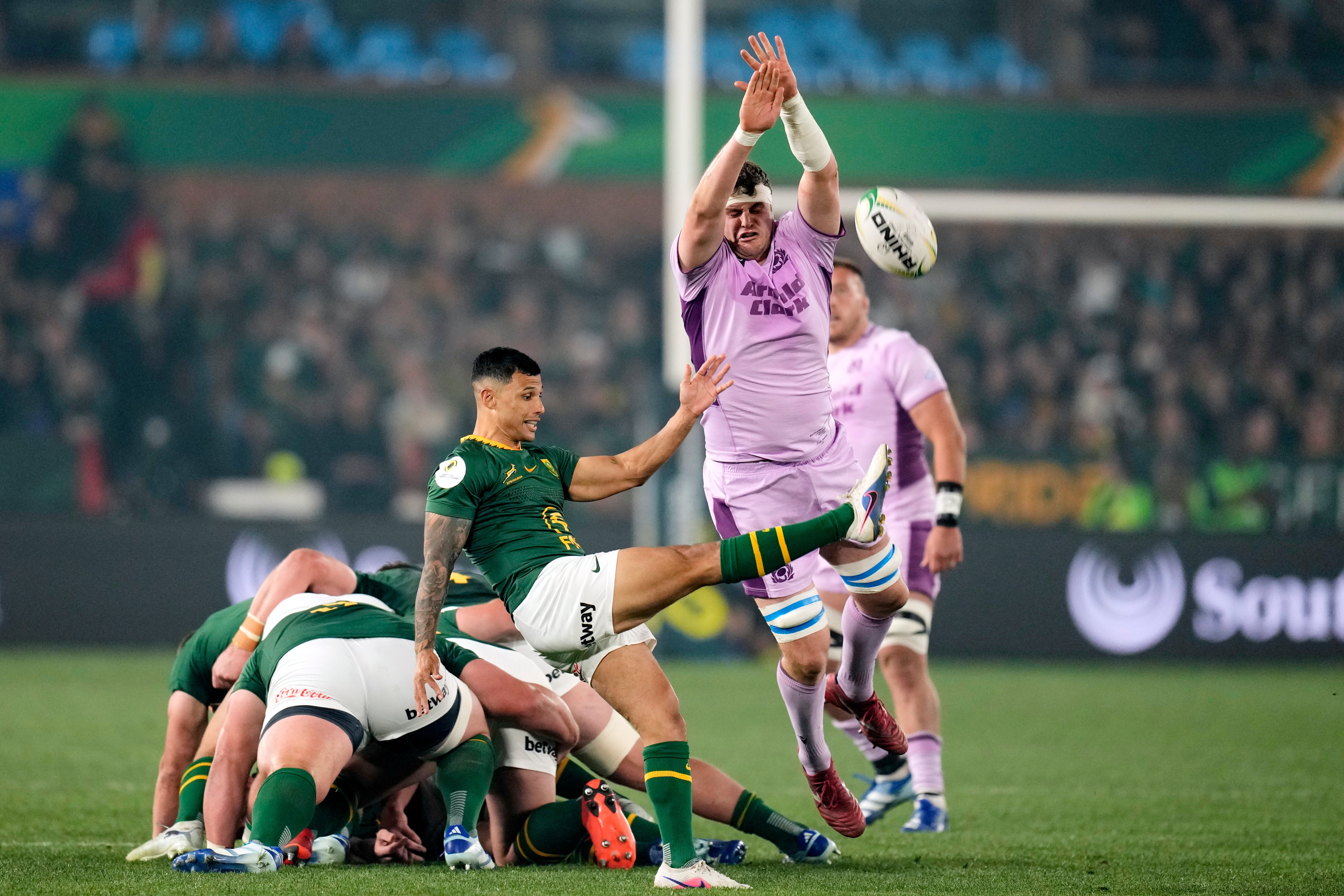 South Africa's Embrose Papier, center, charged down by Scotland's Scott Cummings