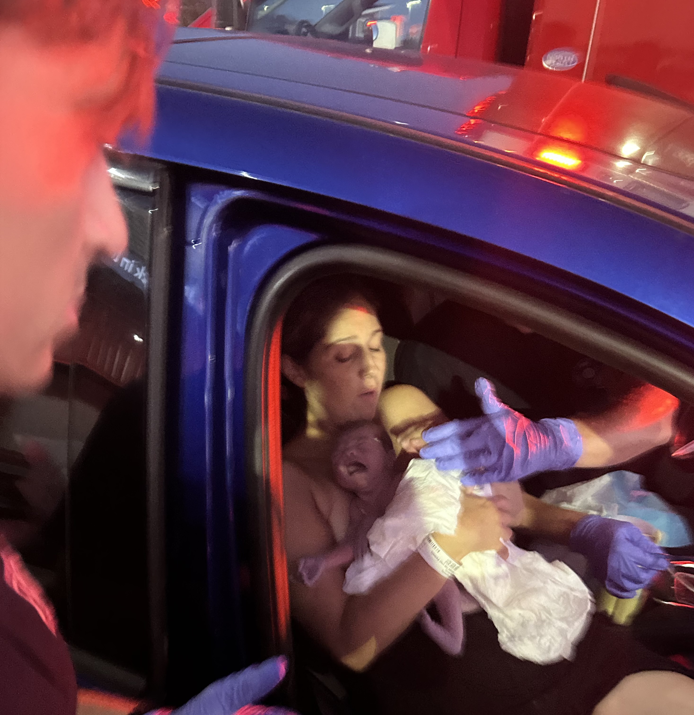 Michelle holding her newborn baby, Valentina, in the front seat of her car.
