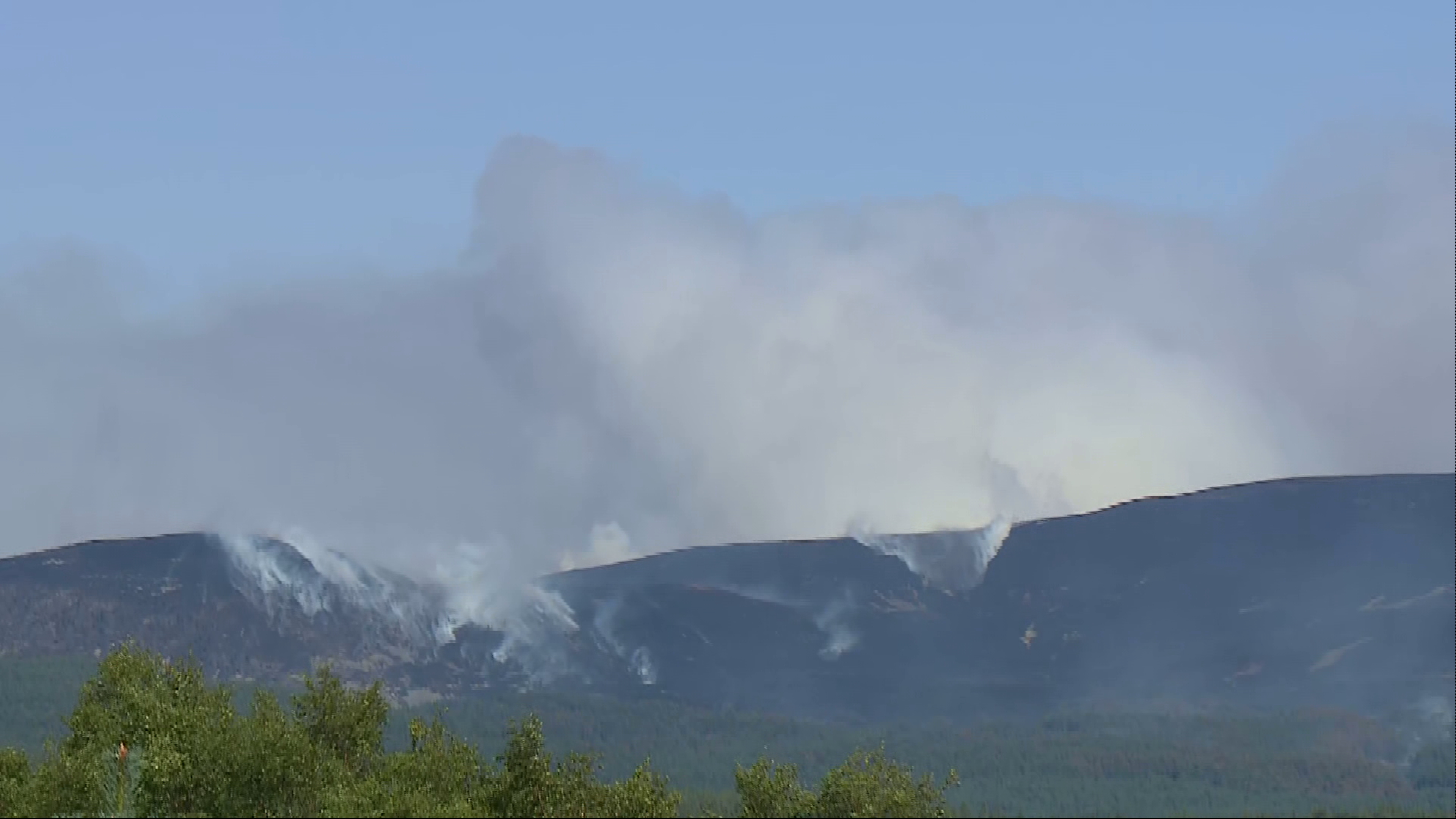 Smoke billows from the hillside after reported change in wind direction
