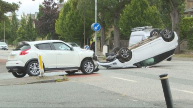 Three taken to hospital after car flips onto roof on busy Edinburgh road